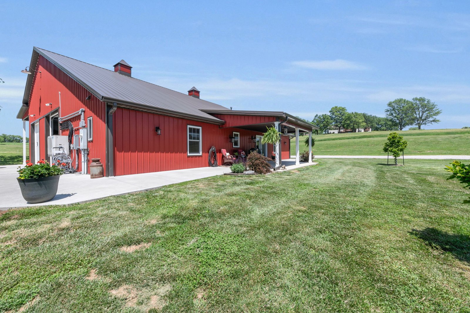 Side angle of the 2021-built barndominium showing the attached four-car garage and metal siding