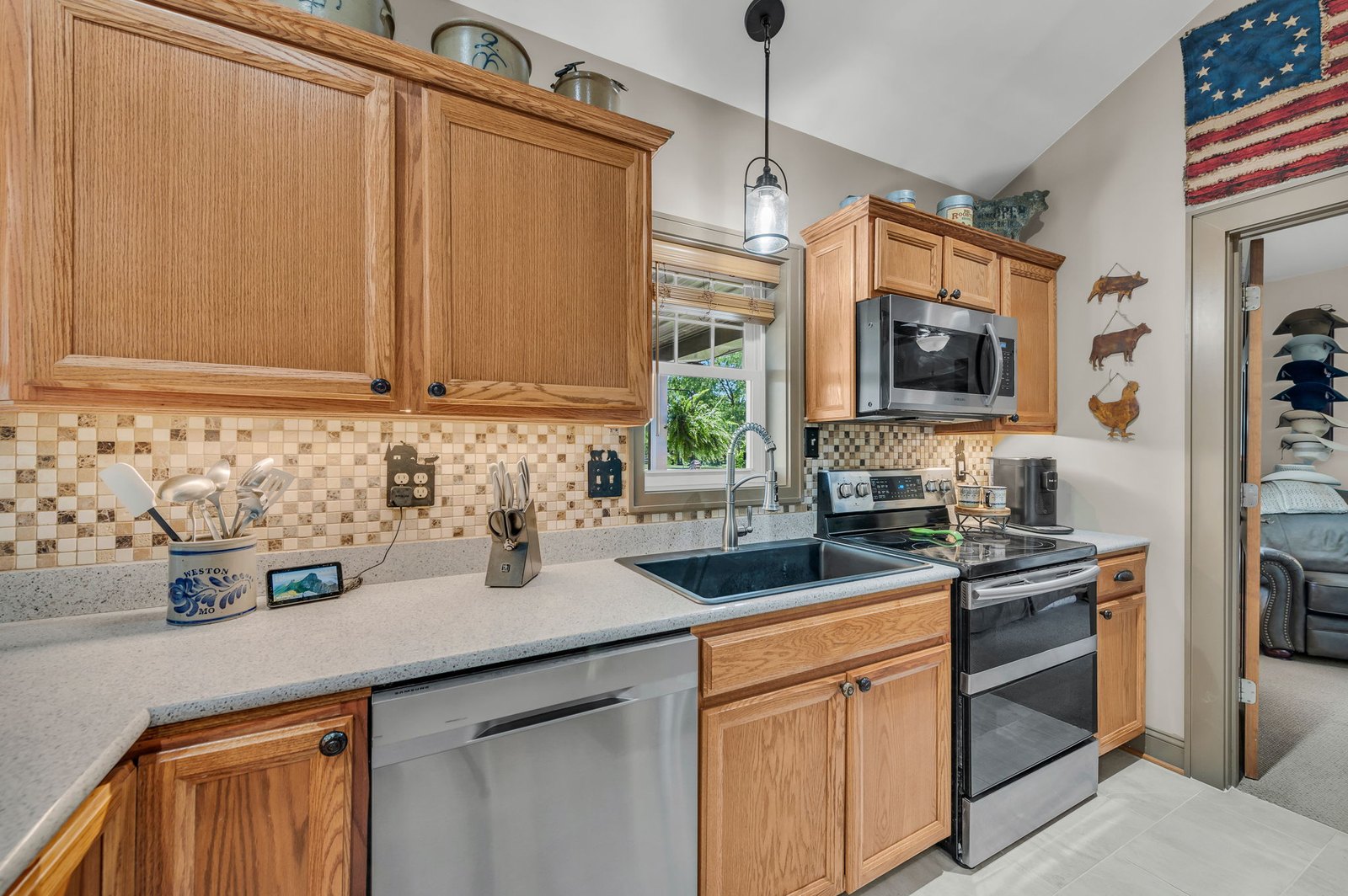 Kitchen with oak cabinetry, stainless appliances, and tile backsplash