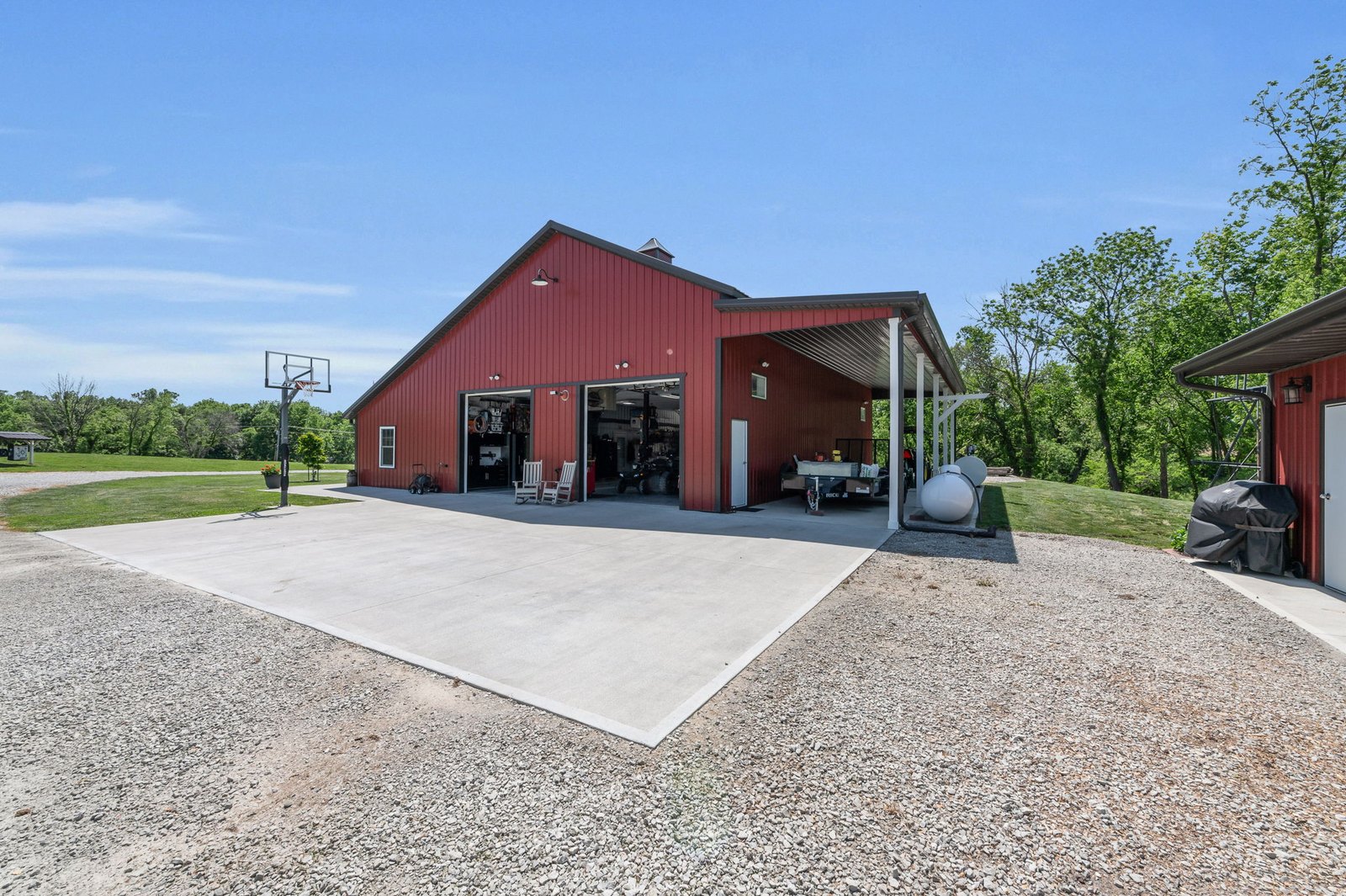 Exterior view with the garage bays open and the separate utility outbuilding alongside