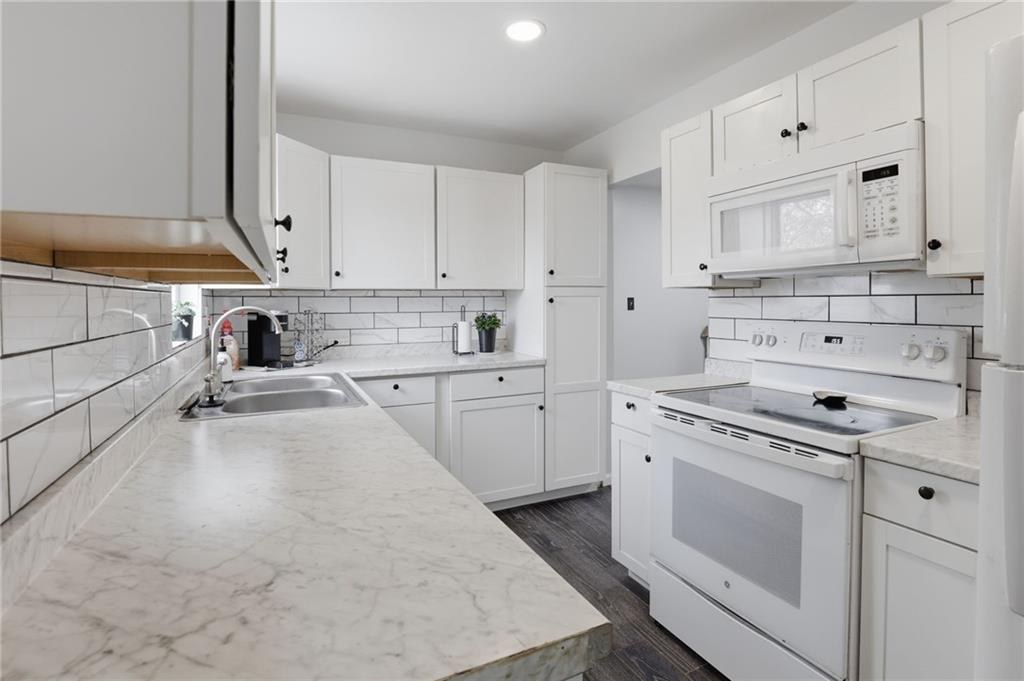 Kitchen with electric range and white cabinetry in Crestview, Kansas City, Missouri