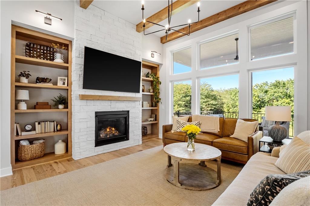 Great room with stone fireplace, built-ins and wood beams in Summit View Farms, Lee's Summit, Missouri