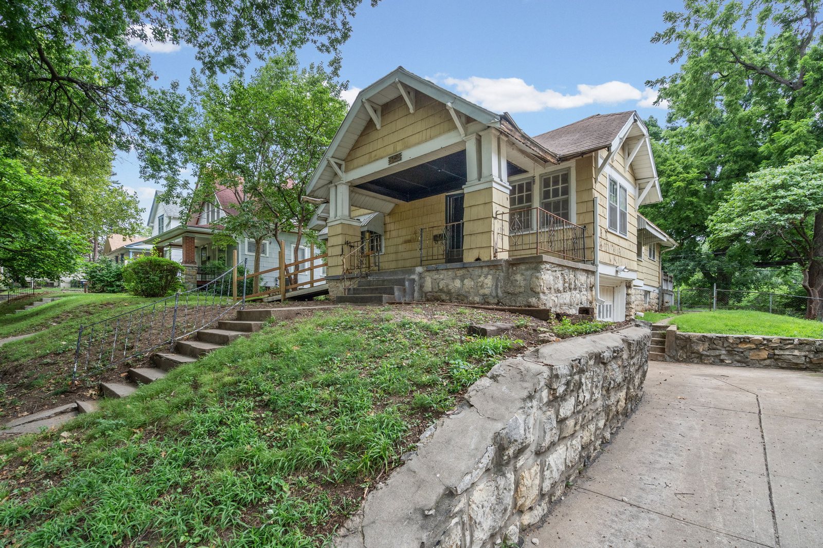 Private concrete side driveway of this Epperson Place bungalow leading down to the tuck-under basement garage
