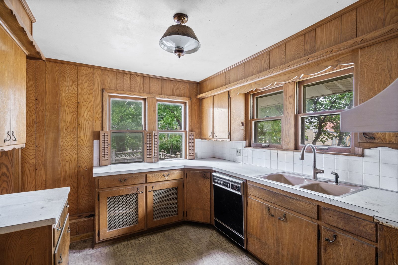 Original wood kitchen cabinets and tile counters in the 1923 kitchen of this Epperson Place bungalow