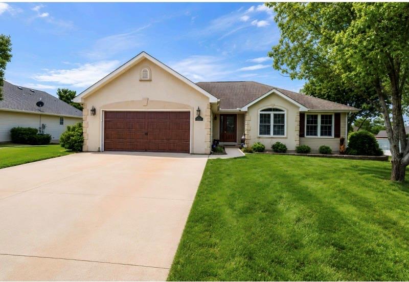 Front exterior of a stucco and siding ranch home with a two-car attached garage in the Eagle's Landing neighborhood of Cameron, Missouri