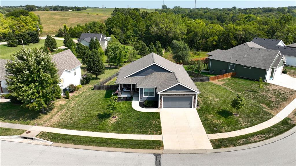 Aerial view of a ranch home in Fiddler's Ridge, Weston, MO, with the tree line behind it