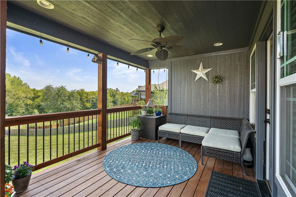 Covered deck overlooking a fenced backyard and tree line in Weston, MO