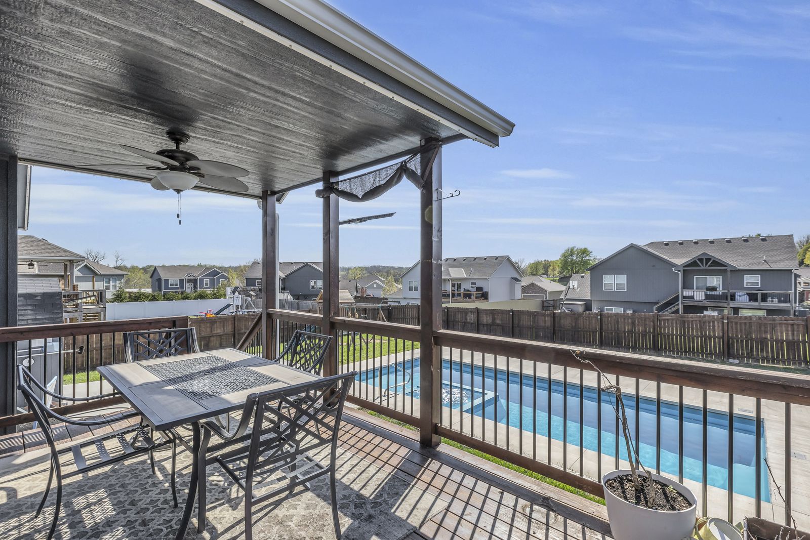 Covered deck overlooking a saltwater pool and fenced backyard in Weston, Missouri