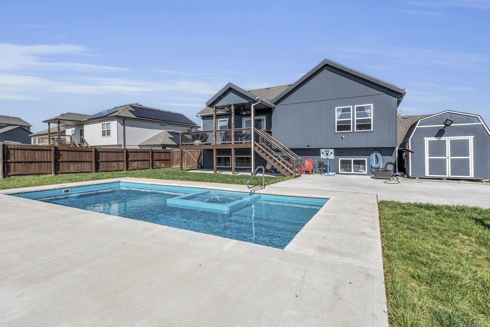 Privacy-fenced backyard with extended concrete patio and pool in Weston, Missouri