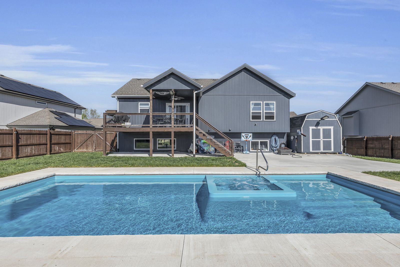Rear of a 2019 Weston, Missouri home with a saltwater pool, spa and covered deck