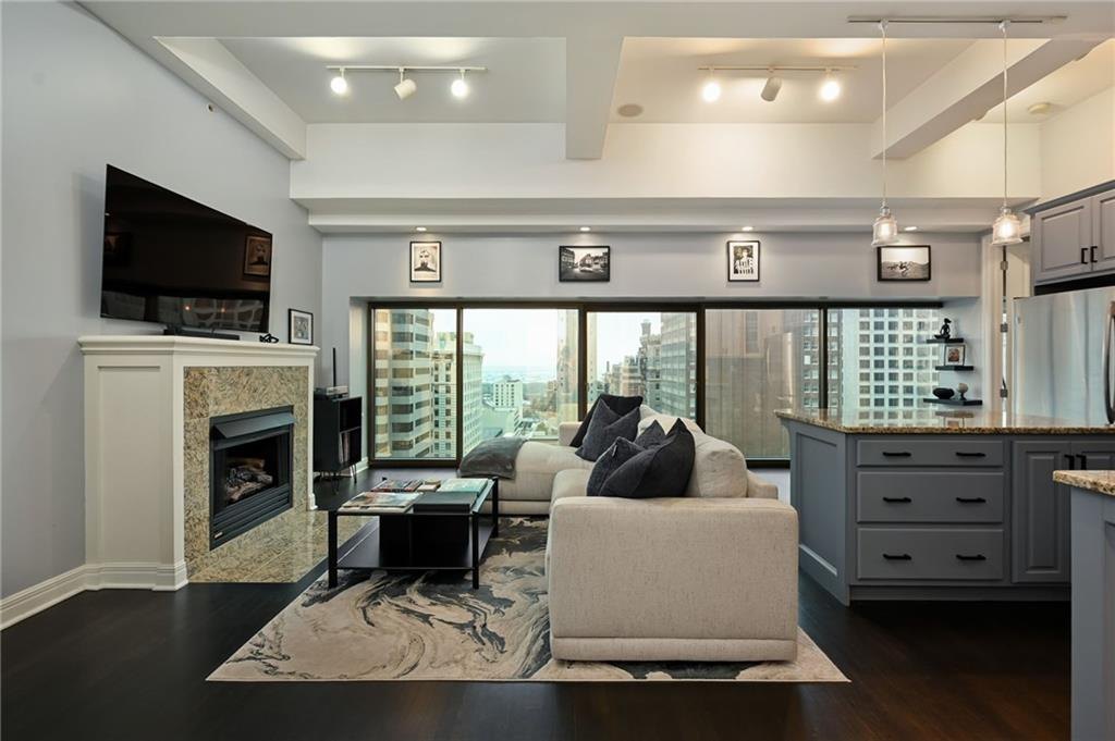 Open living room with a gas fireplace and floor-to-ceiling windows looking out at the skyline, Wallstreet Towers, downtown Kansas City, MO