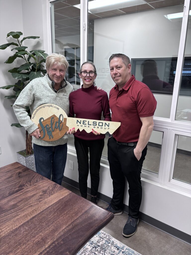 Susan and Donald with Casey Kempter holding the Nelson Home Group sold key on closing day