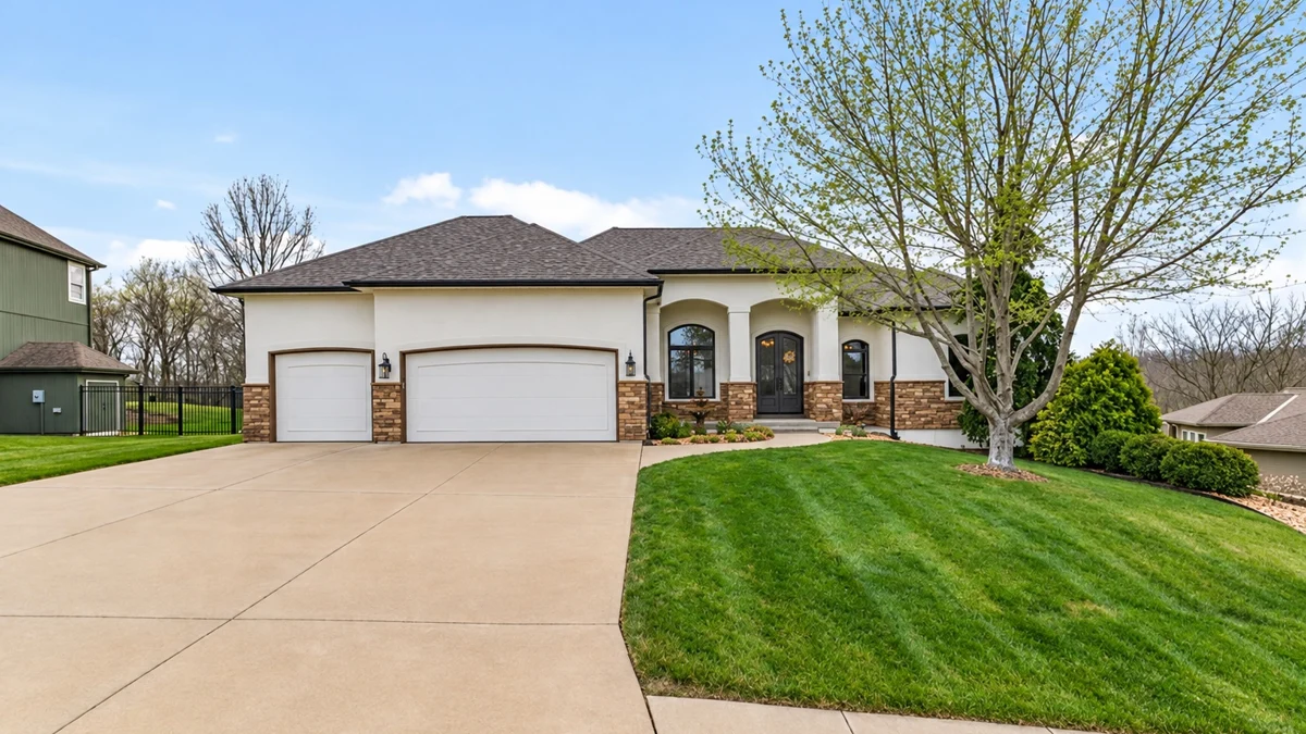Stucco and stone home with a three-car garage in Indigo Hills, Blue Springs, Missouri