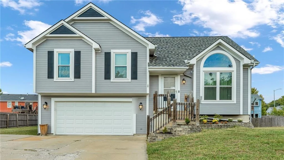 Gray split-level home with a two-car garage in DeMeadows Estates, De Soto, Kansas