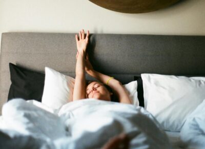 woman waking up with natural light in the bedroom 