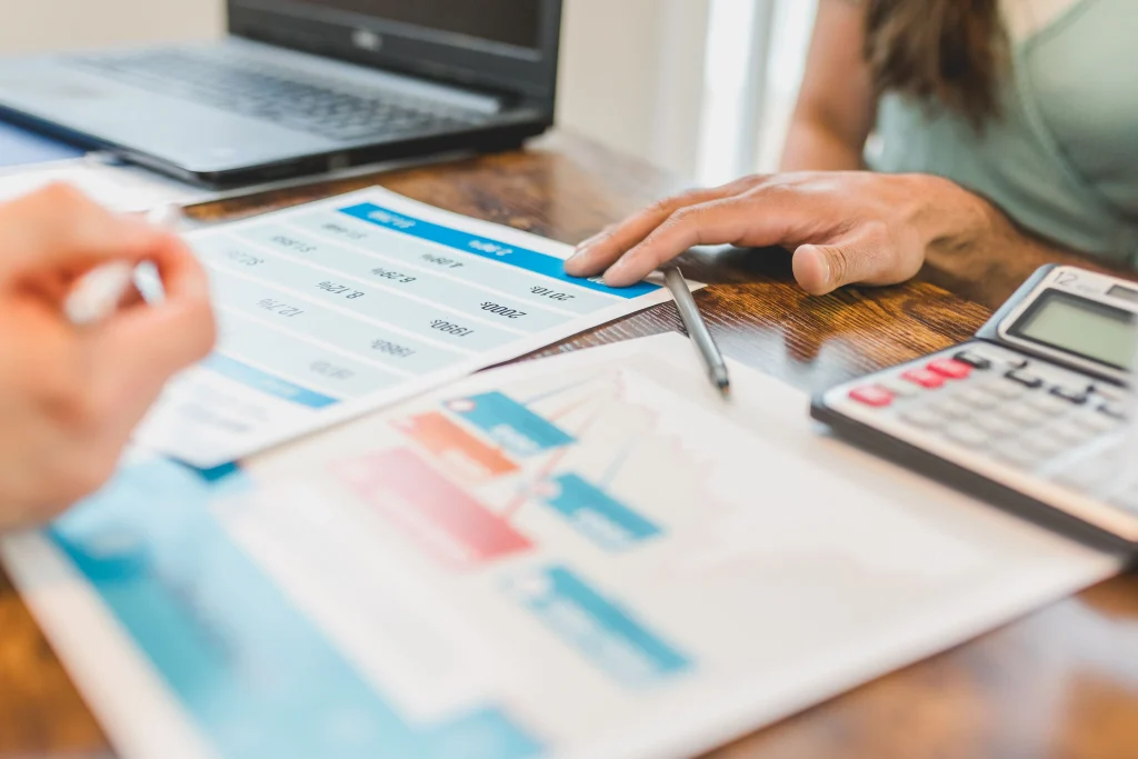 Market analysis on a desk, hands surrounding.
