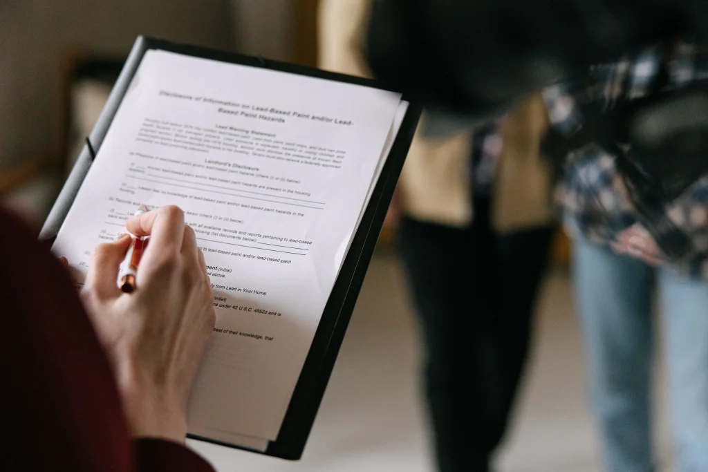 Hand holding a lease, reviewing it with a pen