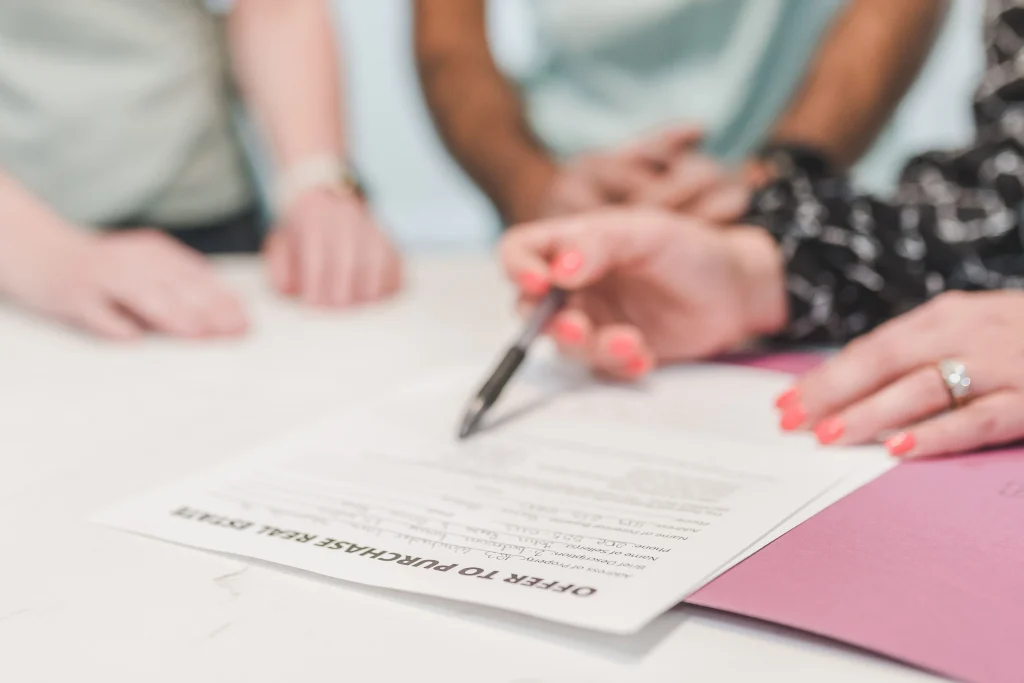 Hands on a desk reviewing real estate offer