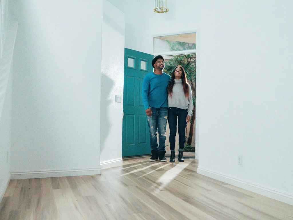 2 people walking into a house to tour it