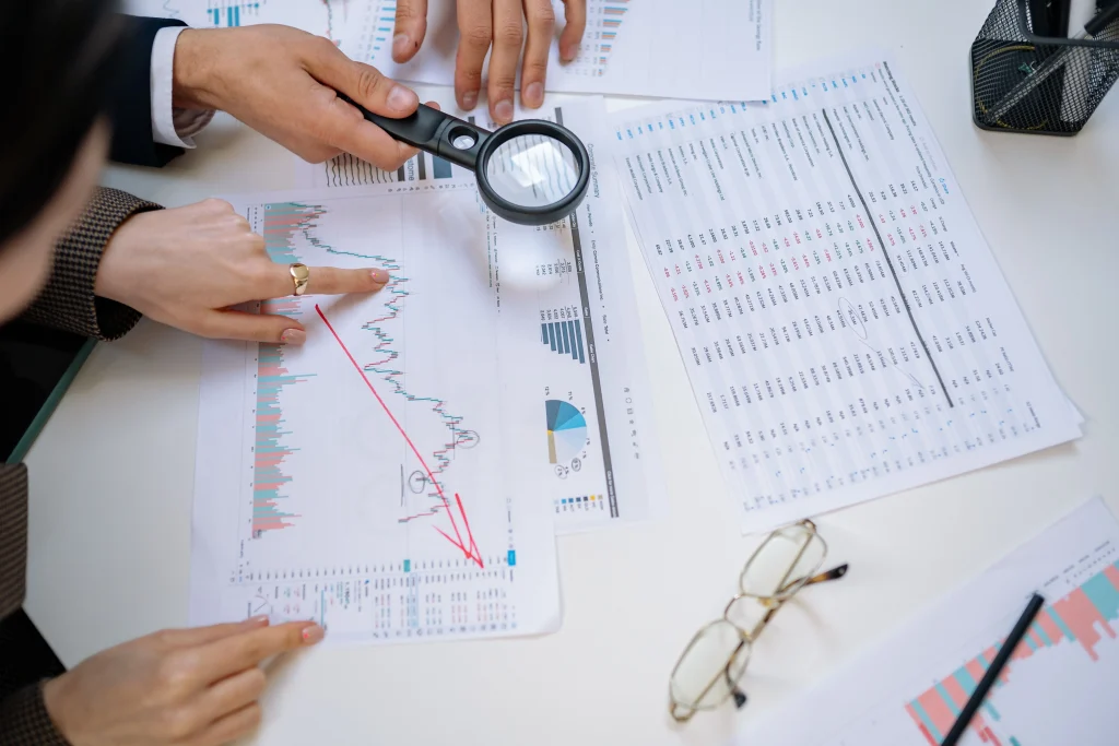 Charts on a desk with a magnifying glass