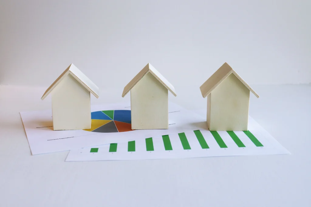 3 model homes over a pricing graph on a table