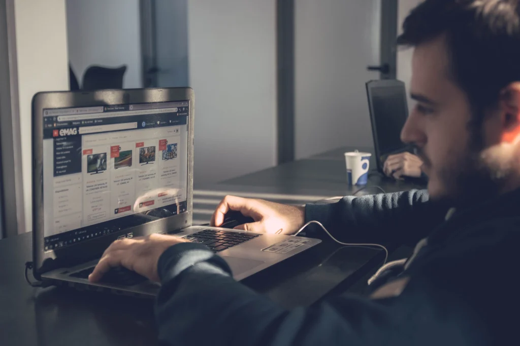Man sitting at desk looking at laptop