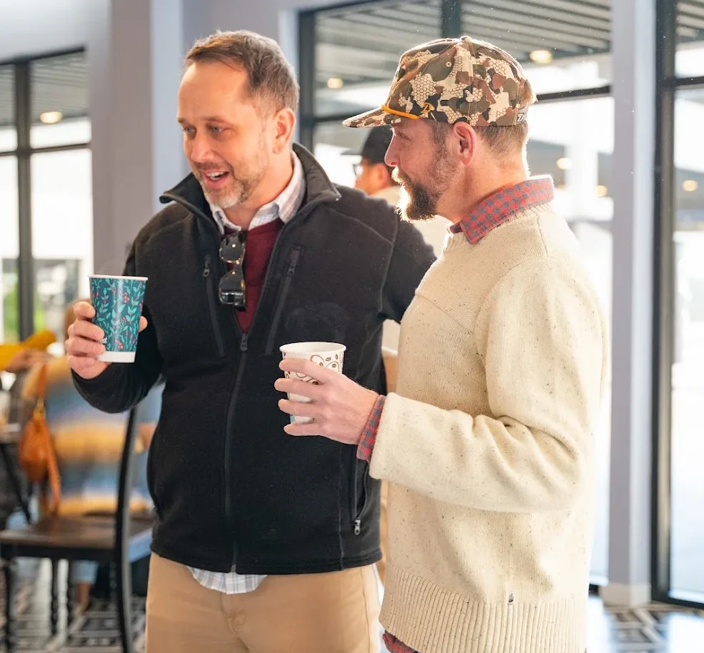 Real Estate Agent conversing while holding cups