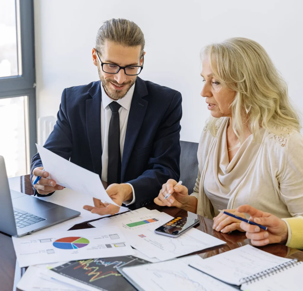 Fayetteville real estate agent consulting potential clients at a table with papers spread apart