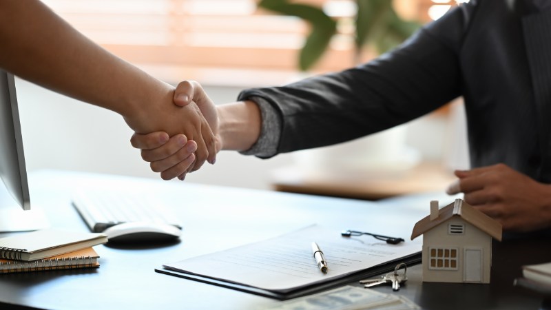Young woman handshaking with real estate agent
