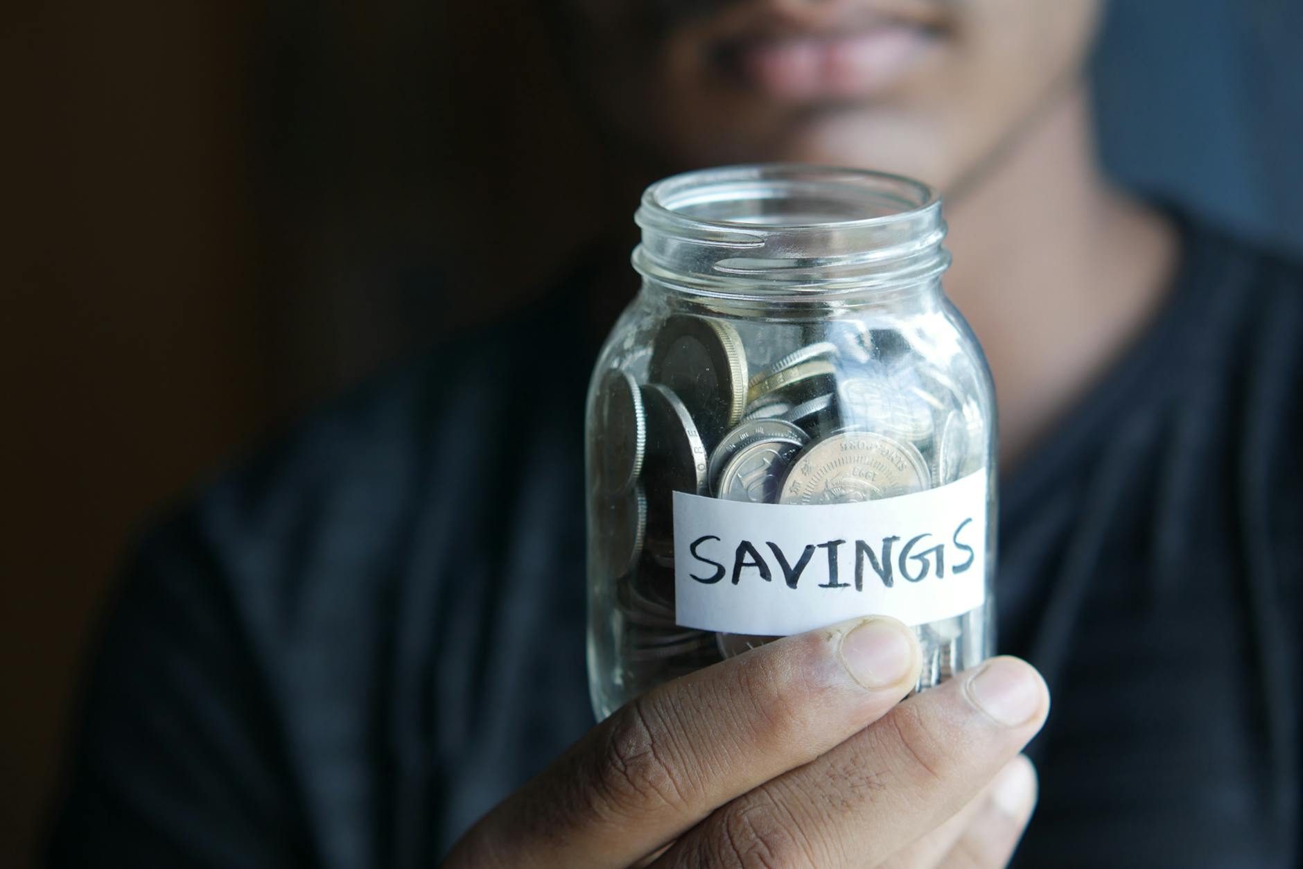 Glass jar filled with coins representing home down payment savings