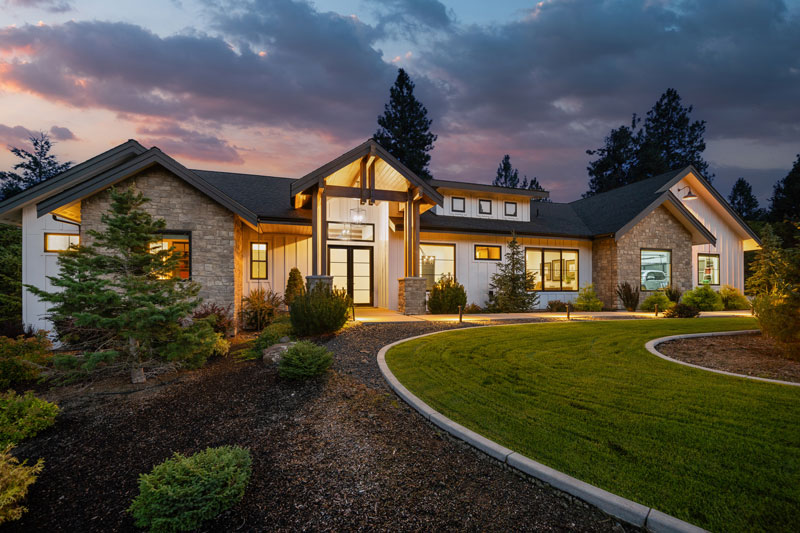 Luxurious covered outdoor deck with fire pit, comfortable seating, and stunning twilight forest views