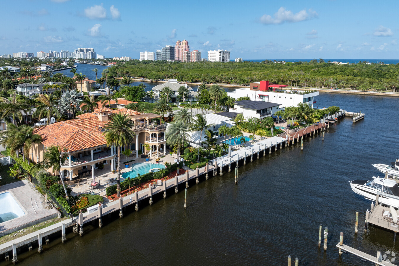 Aerial view of Coral Ridge in Fort Lauderdale, featuring a mix of waterfront and inland homes, a golf course, tree-lined streets, and access to the Intracoastal Waterway, with the ocean visible in the background.