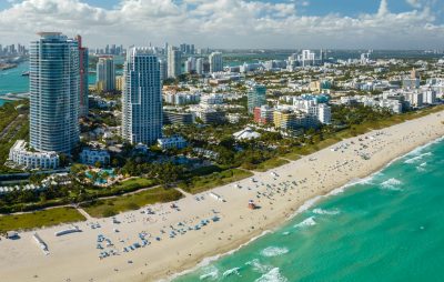 Miami Beach city with high luxury hotels and condos and sandy beachfront. High angle view of tourist infrastructure in southern Florida, USA