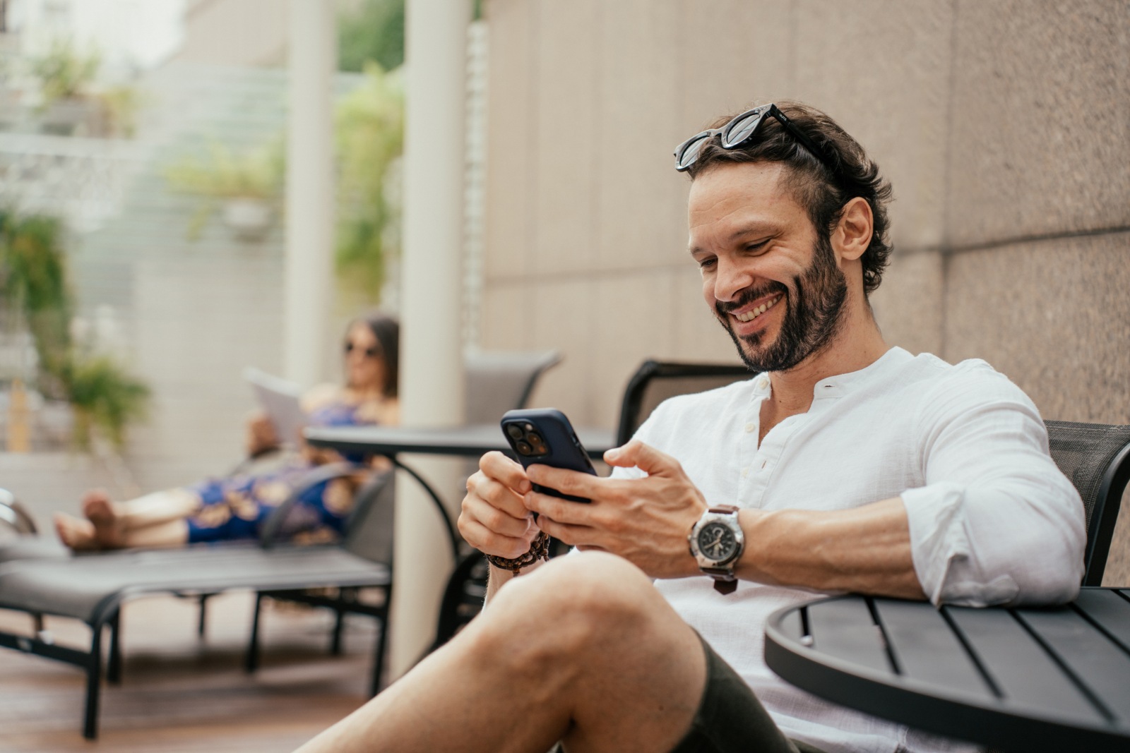 Man relaxing by the pool using smartphone