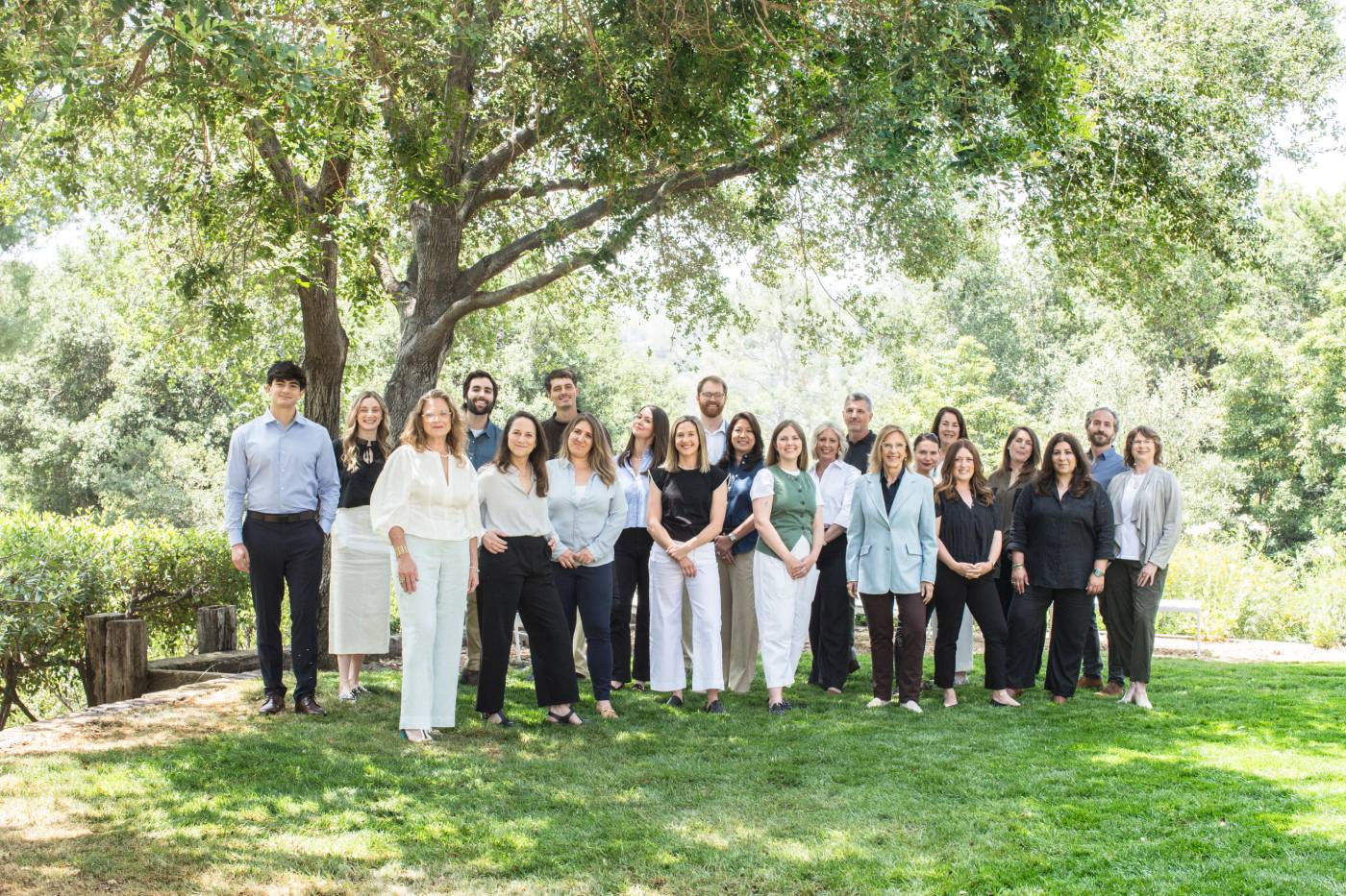 The Teresa Fuller Real Estate Team standing together outdoors under a large tree