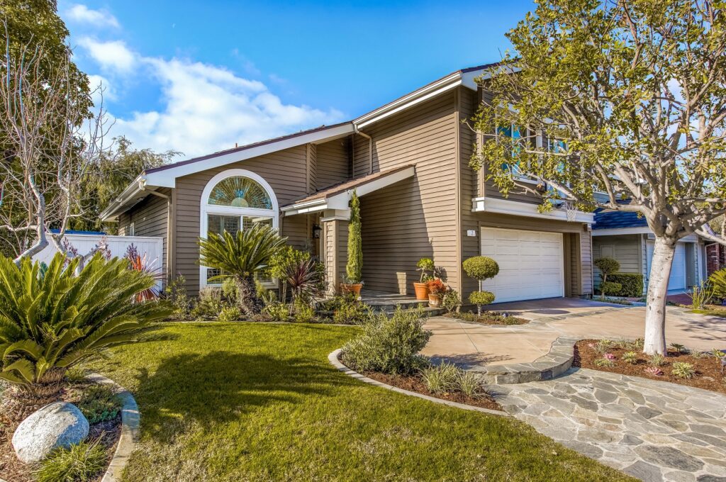 Exterior of classic Woodbridge Irvine single family home with mature trees and 1980s architectural style