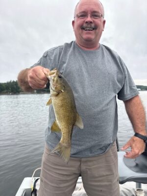 Angler holding a bass caught while fishing on Great Sacandaga Lake with Aaron’s Guide Service.