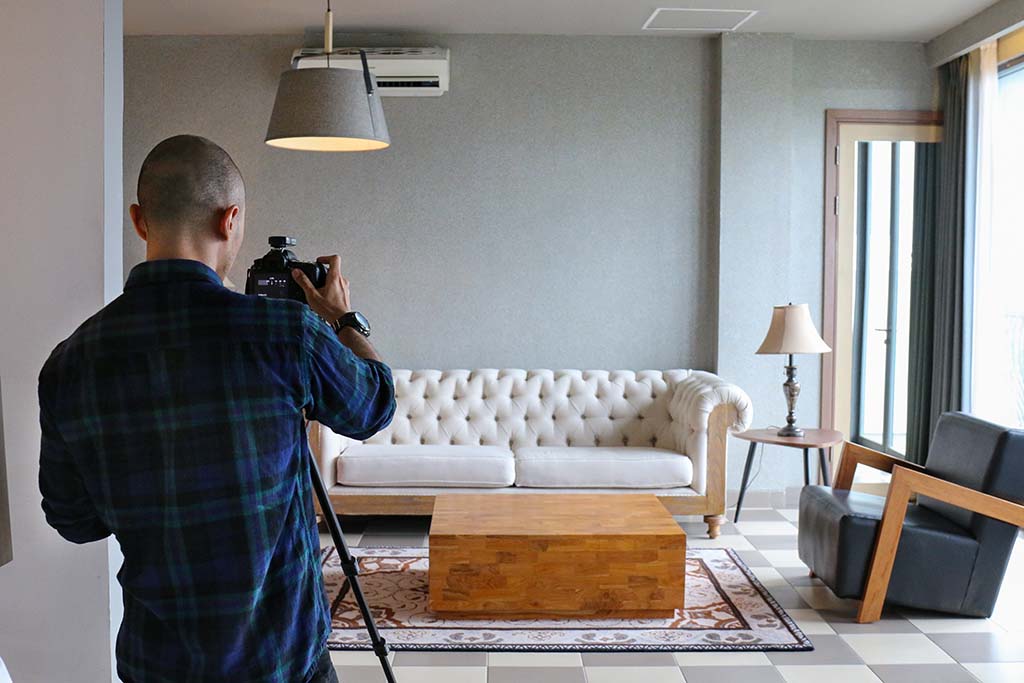 A photographer taking shots of the inside of a house.