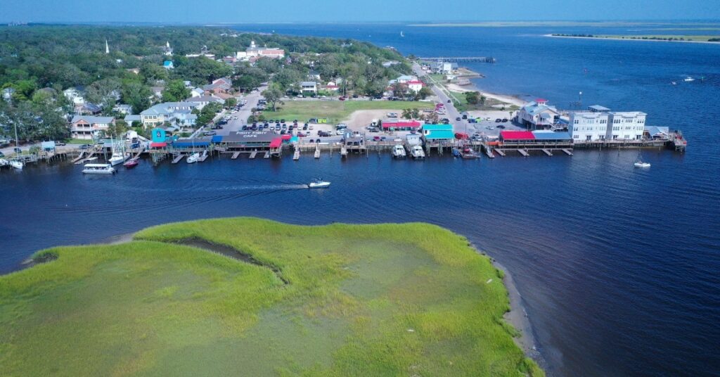 Looking at the resturants at Southport NC. The colorful roofs line the shore for the boats to dock at. View of the city behind.