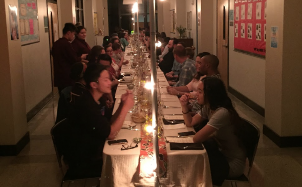 Students enjoying a Candlelit Long Table Dinner at Ida B. Wells High School