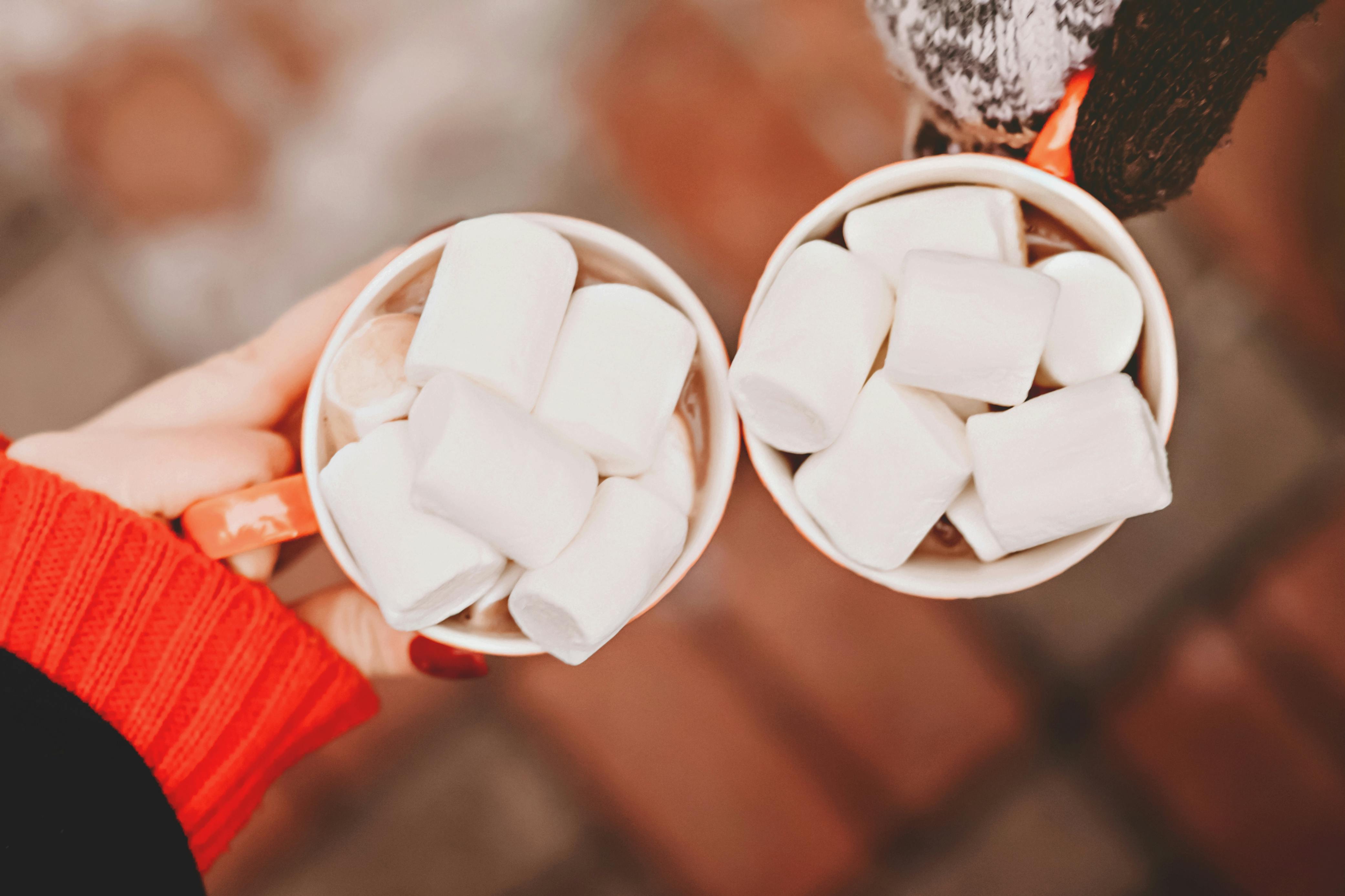 Overhead view of two mugs of hot chocolate with marshmallows