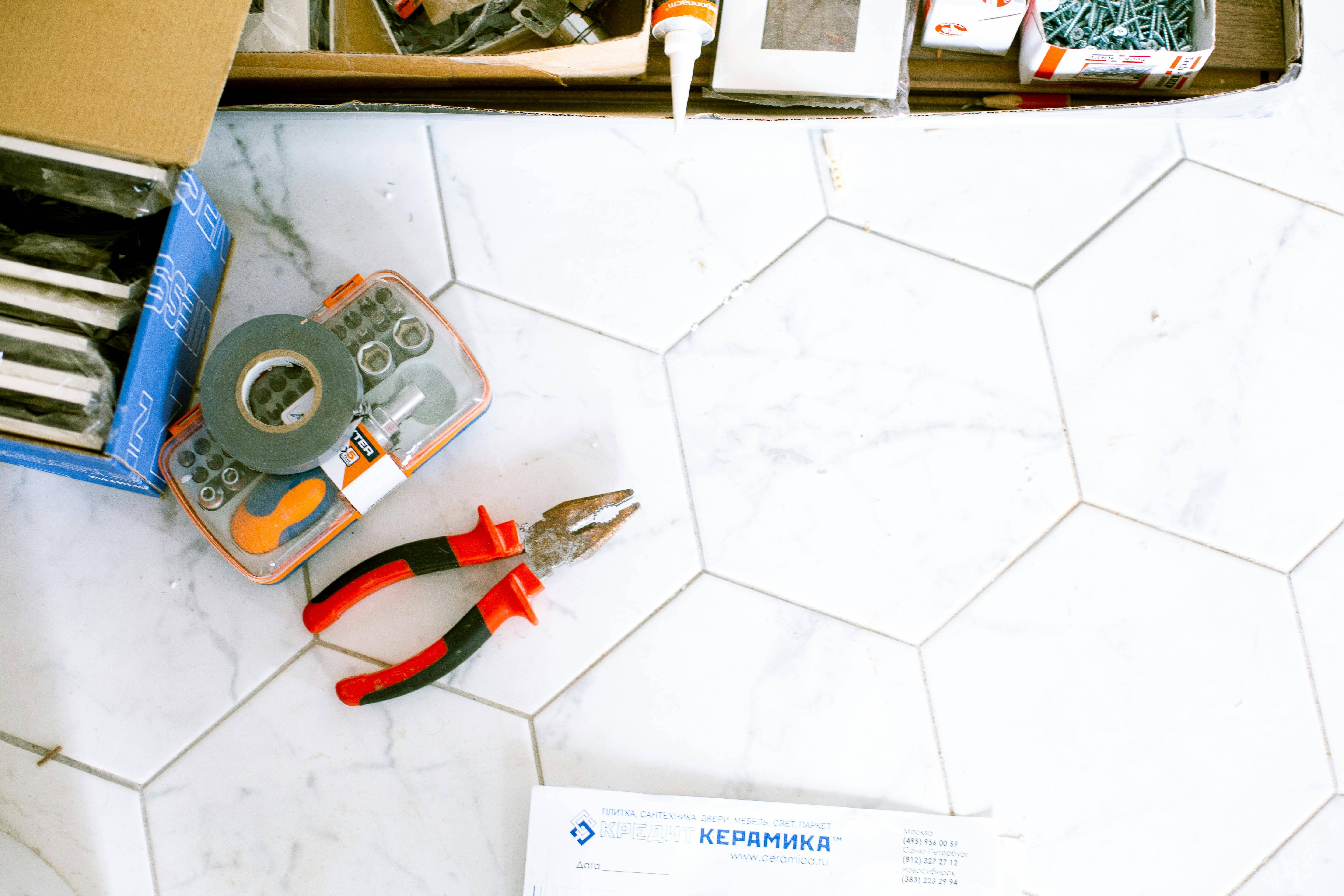 Home improvement tools on a marble hex tile floor