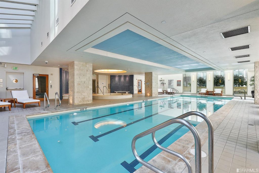 Luxurious rooftop pool and spa area at 333 1st St SoMa condo building, featuring loungers, cabanas, and breathtaking city views, perfect for staging your highrise property.