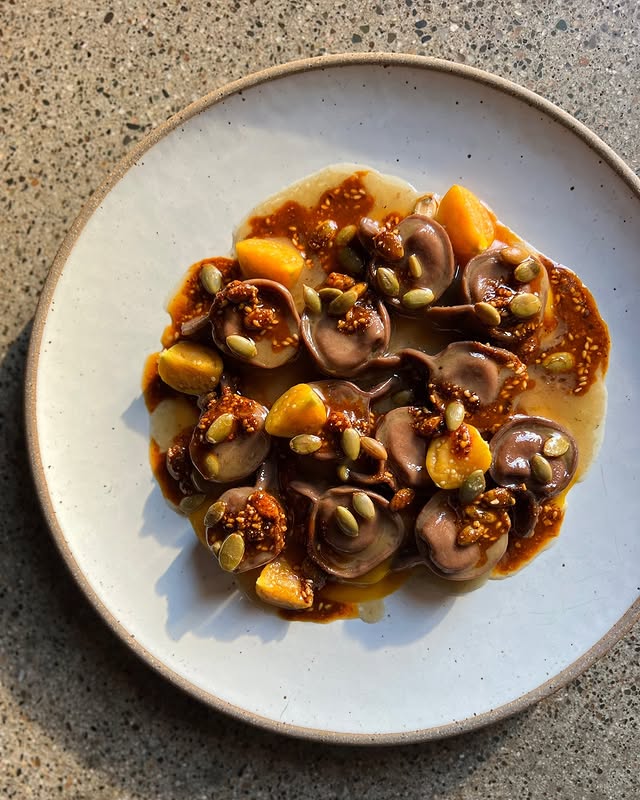 Squash cappelletti pasta dish with a sage brown butter sauce, husked cherry marinade, and pepitas from Flour + Water