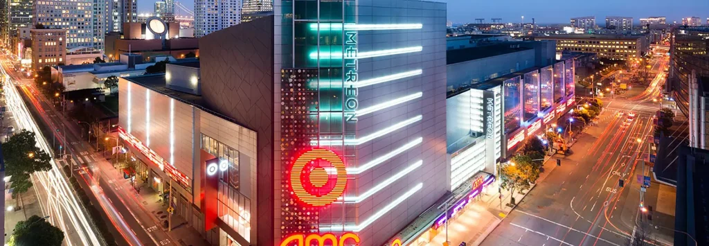 Aerial View of large shopping complex at night with Metreon lettering lit up in a teal blue and an AMC sign beneath it