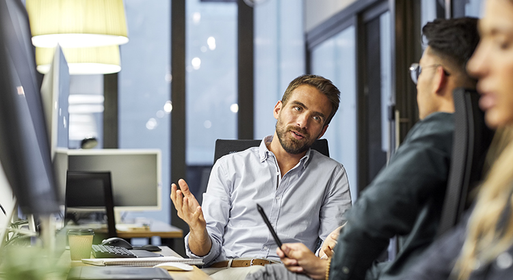 Male coworkers discussing during meeting in office