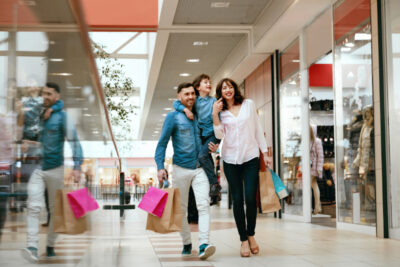 Family carrying shopping bags while walking through an indoor shopping mall