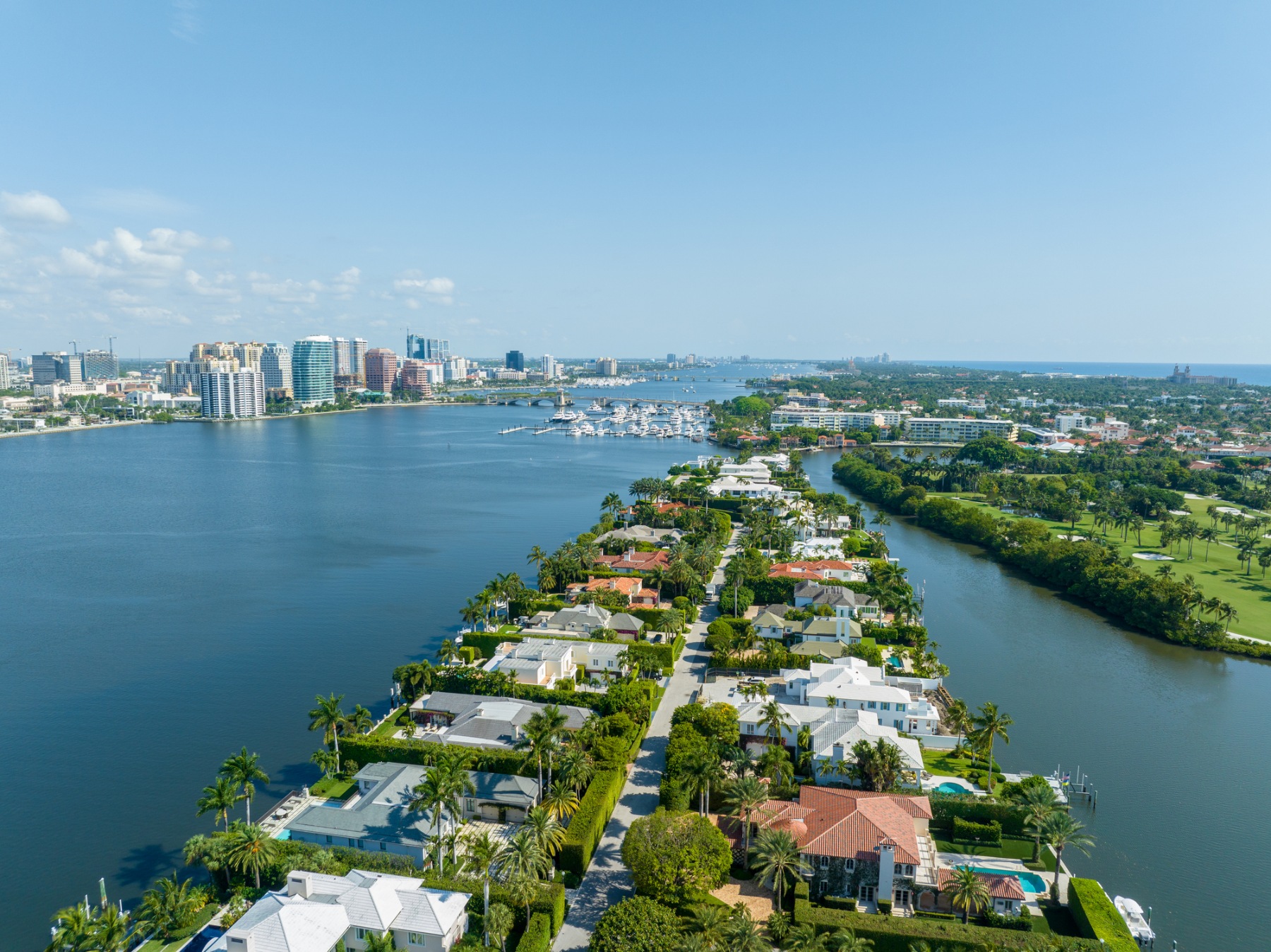 Aerial view of a waterfront neighbourhood with canals, bay, and city skyline