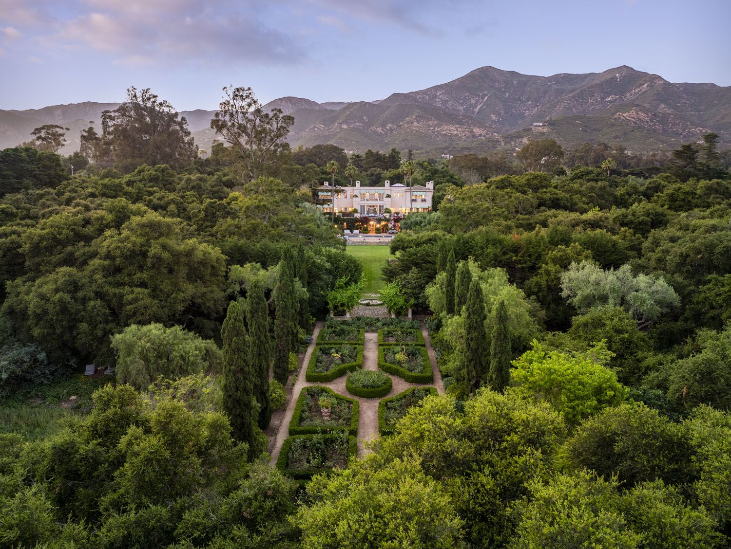 A sweeping tableau of legacy: the Far Afield Estate, seen from the formal gardens, with the Santa Ynez Mountains in the background.