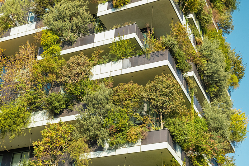 Close up of vertical forest building with lush greenery and trees integrated into modern architecture, Milan, Italy. Vertical garden and landscaping, innovative architecture, urban sustainability