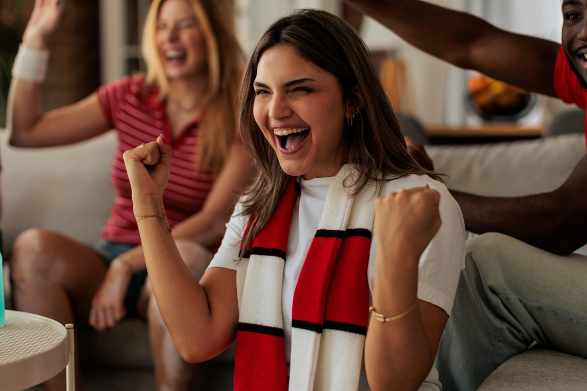 Happy Woman Cheering During Exciting Sports Match at Home
